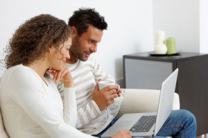 Portrait of a relaxed young couple using a laptop at home